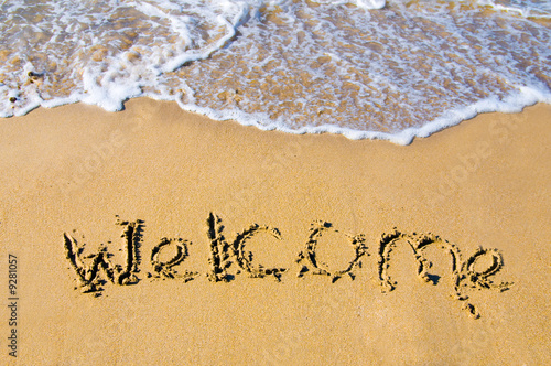 welcome written in a sandy tropical beach