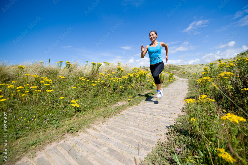 A young sporty woman running in the countryside
