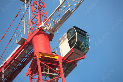 Red and white crane on bright blue sky