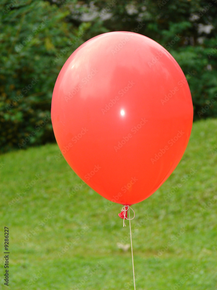Red balloon on background a green grass