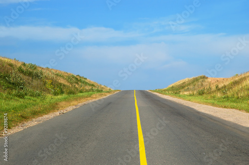 Empty country highway with summer cloudscape