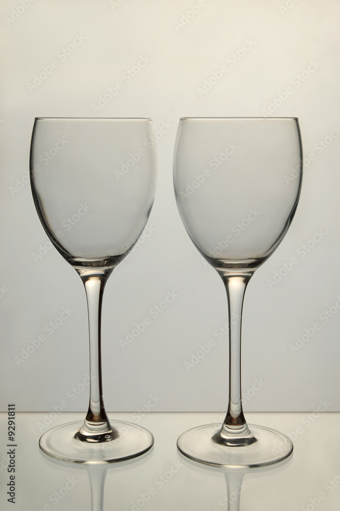 Two empty wine glasses on grey background Two empty wine glasses on grey background