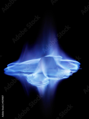 Blue flames burning ice cube and its reflection