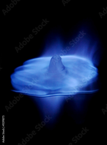 Blue flames burning ice cube and its reflection