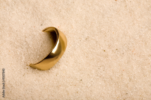 A wedding ring buried in the sand - lost