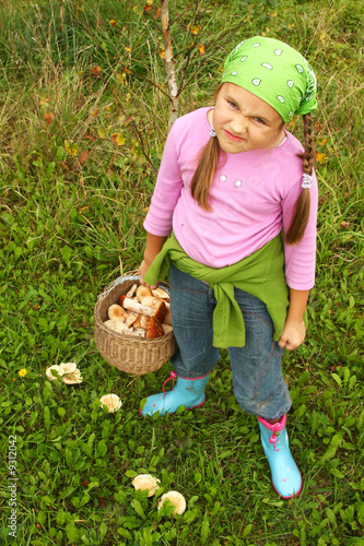 Young girl picking mushrooms, full basket with mushrooms © Ints