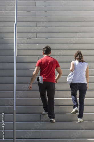 A young couple is walking upstairs.