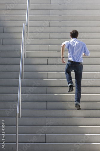 A young, dynamic man is running upstairs.