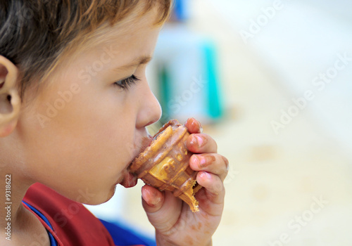 boy eating a near ended Ice cream