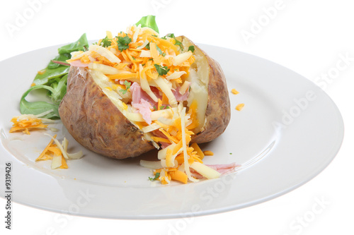 Baked potato filled with ham and cheese with watercress salad