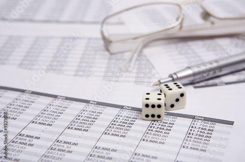 two white dice on the financial shrrt with pen and glasses
