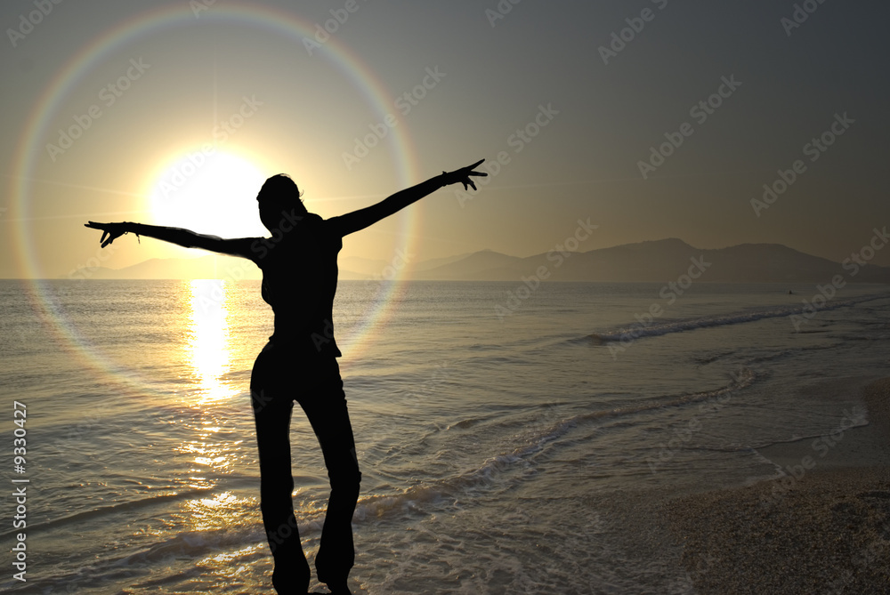 A young woman exults the onset of the vivid sunset
