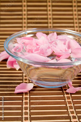 Bowl with rose petals on a wooden napkin