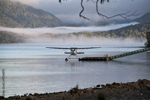 A landed waterplane at the shore - in the foggy hills photo