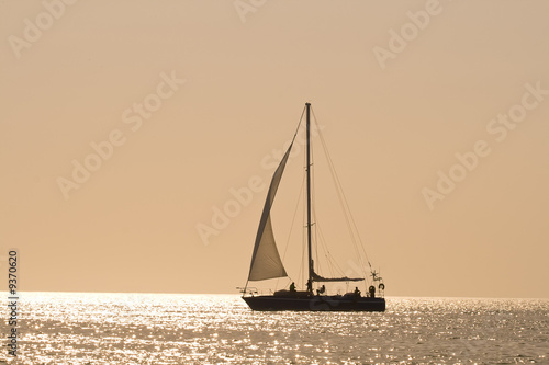 People on a sail boat at the sunset