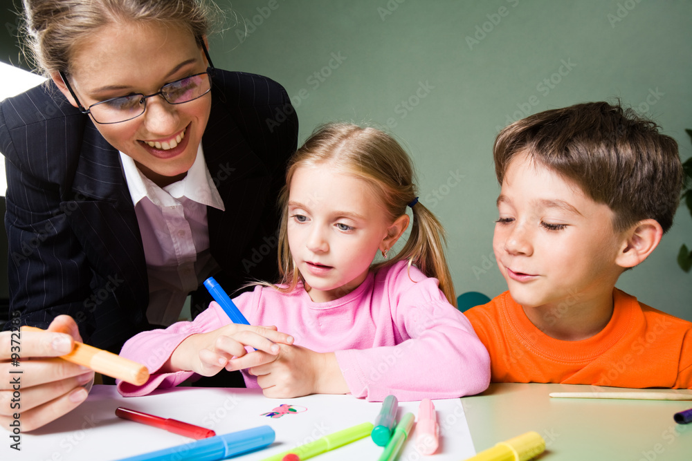 Image of smiling teacher holding highlighter Image of smiling teacher holding highlighter