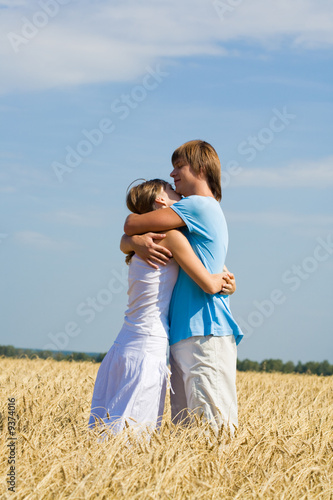 Photo of loving couple in sweet embrace on the field