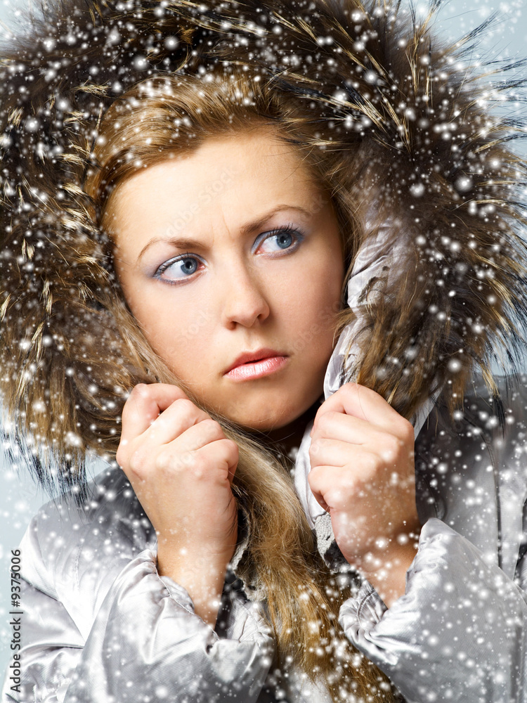 Young women in fur hood with worried expression on face.