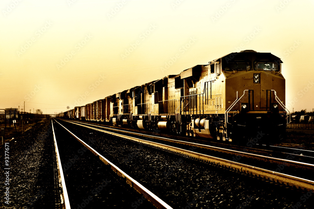 Obraz premium Pociąg towarowy podróżujący przez Arizona o zachodzie słońca