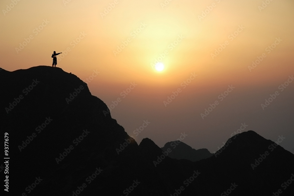 Man on top of the mountain during sunset.