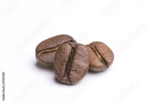 Close up of three coffee beans on white background