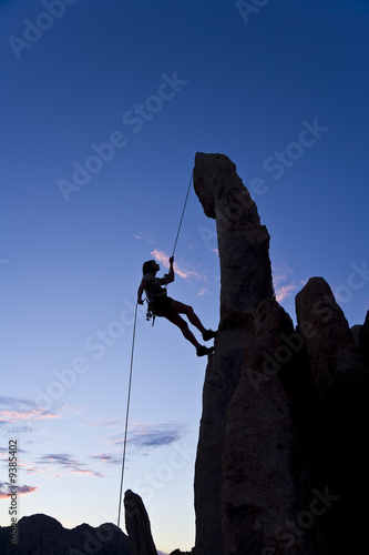 A rock climber rappelling.
