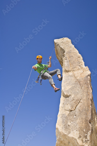 A rock climber rappelling.