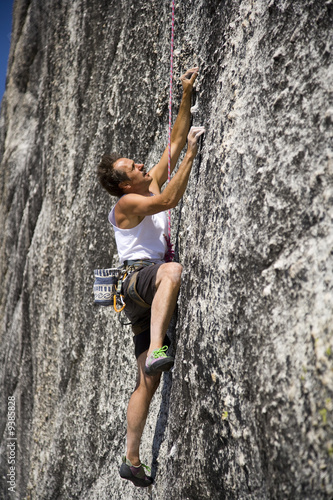 A rock climber scales a steep rock face.