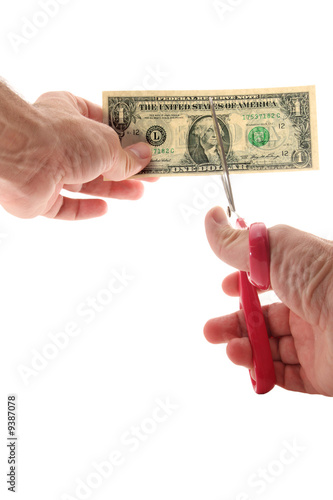 Man using scissors to cut US $1 bill