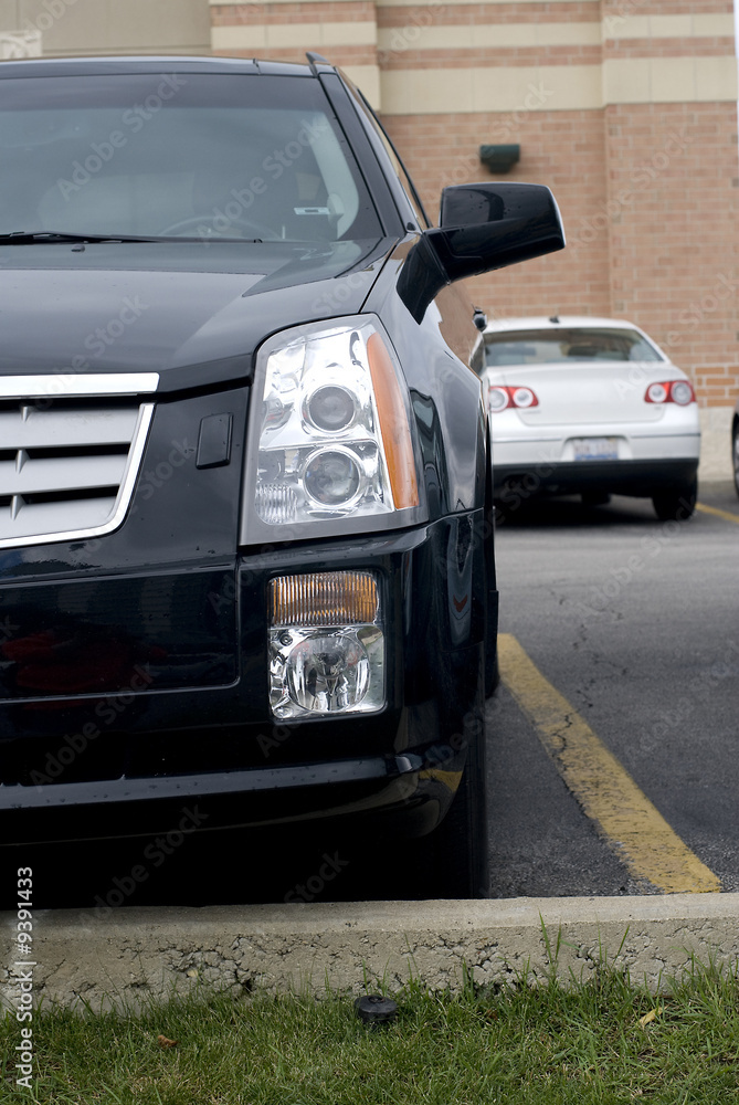 Black Cadillac's front bumper and headlight