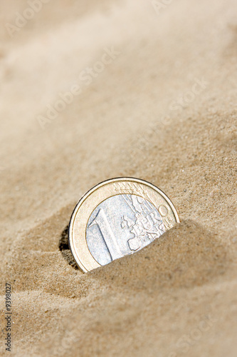 Euro coin in the sand