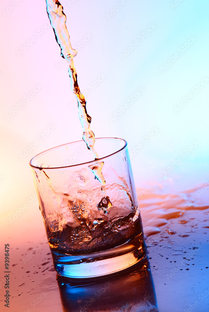 The stream filling an empty glass by alcohol The stream filling an empty glass by alcohol