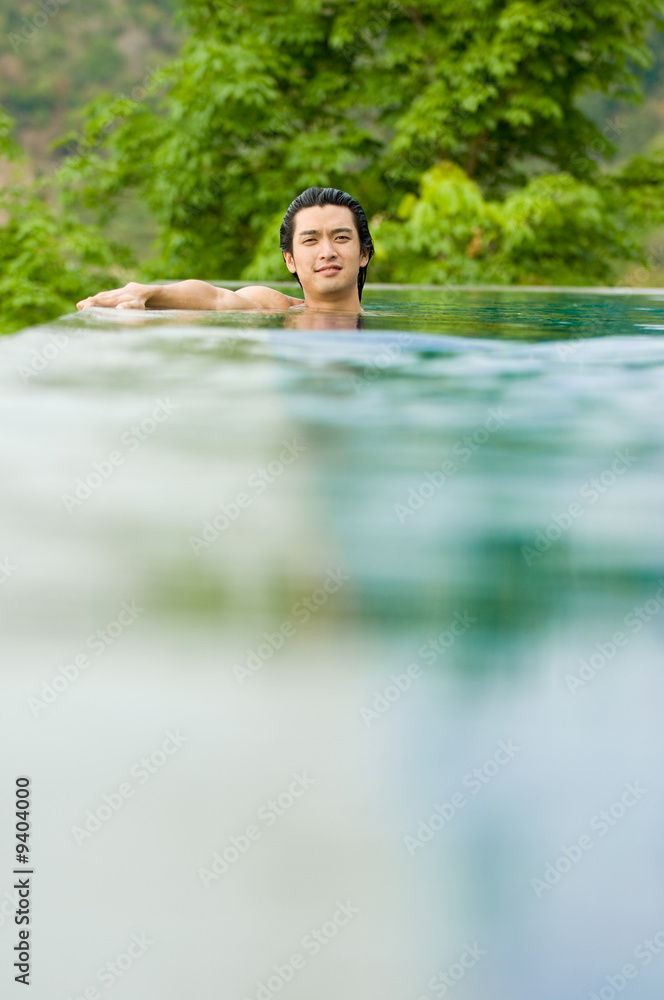 A young man relaxing in a swimming pool A young man relaxing in a swimming pool