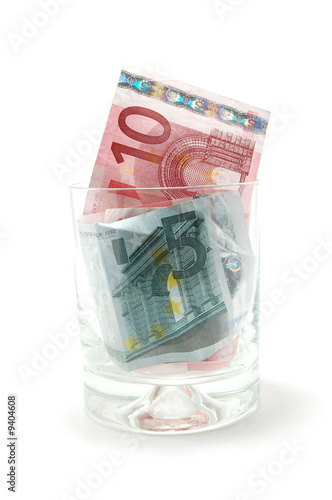 Some euro banknotes in a tumbler isolated on white background