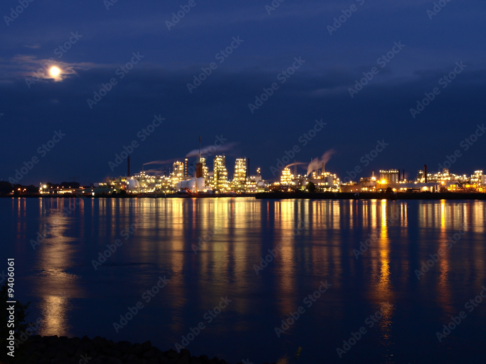 River reflections of a petrochemical plant at full moon