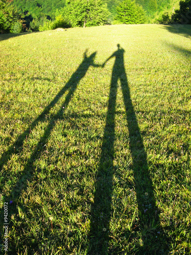 Man and child silhouettes at afternoon sun beams
