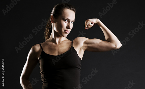 muscular woman over dark background