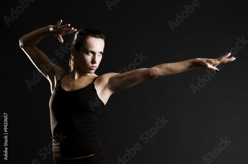 serious sportswoman in pose over dark background