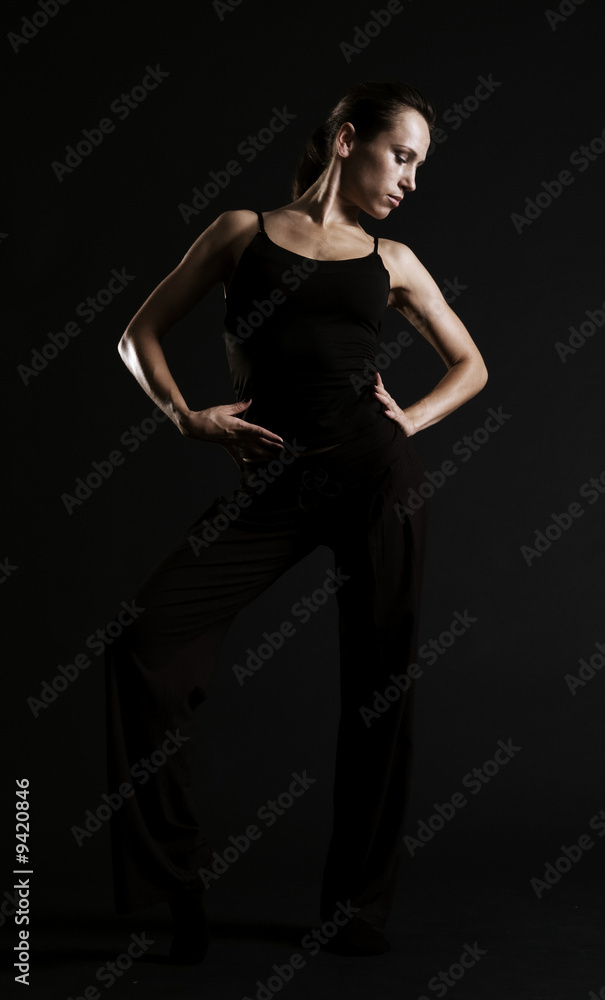 young dancer posing over dark background young dancer posing over dark background