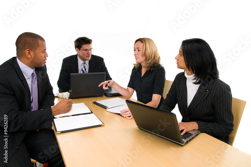Two women and a two men sit at conference table