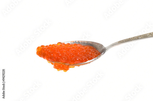 Red caviar at spoon on whit...