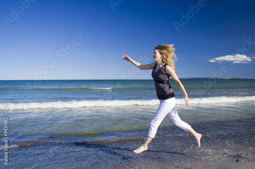 Fototapeta Naklejka Na Ścianę i Meble -  Frau rennt am Strand entlang