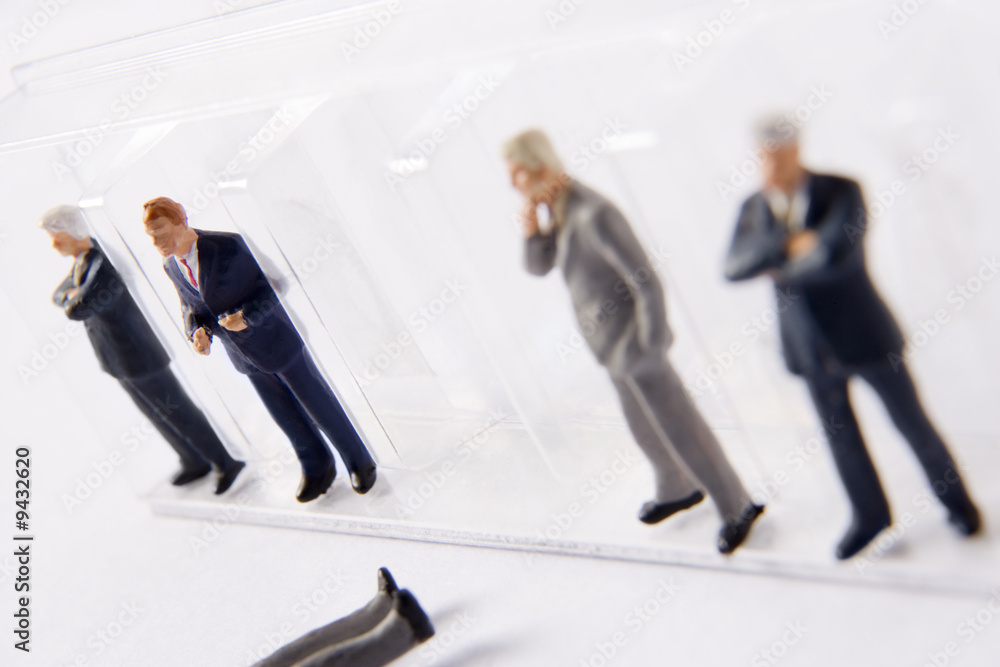 Row Of Businessman Figurines, With One Fallen Out Of Line Row Of Businessman Figurines, With One Fallen Out Of Line