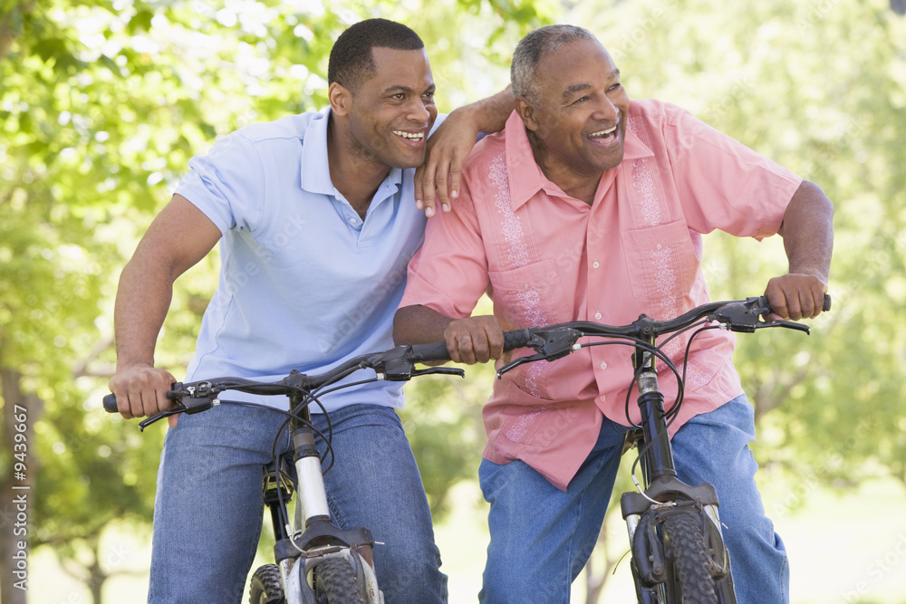 Fototapeta premium Two men on bikes outdoors smiling