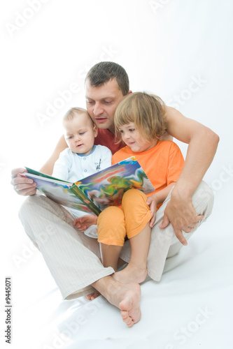 young father reading fairy tale to children