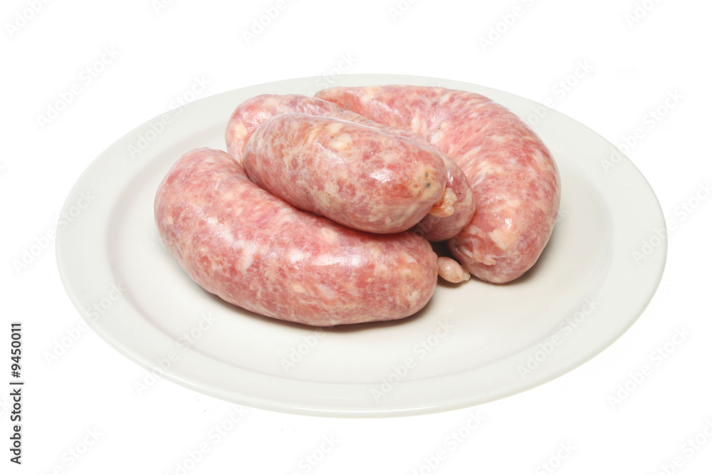 Raw pork sausages on a plate isolated on white