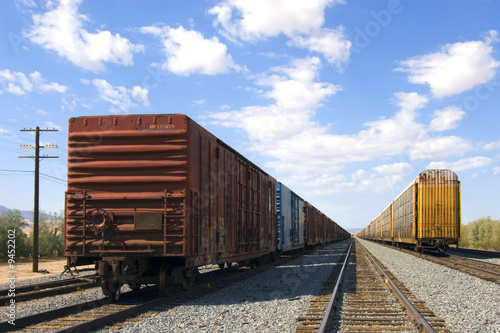 parked railroad freight cars sitting on tracks in desert