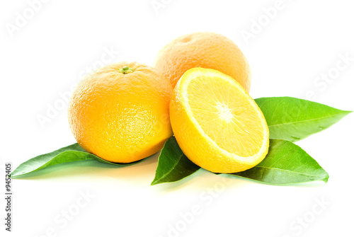 two oranges and half with leaves over white