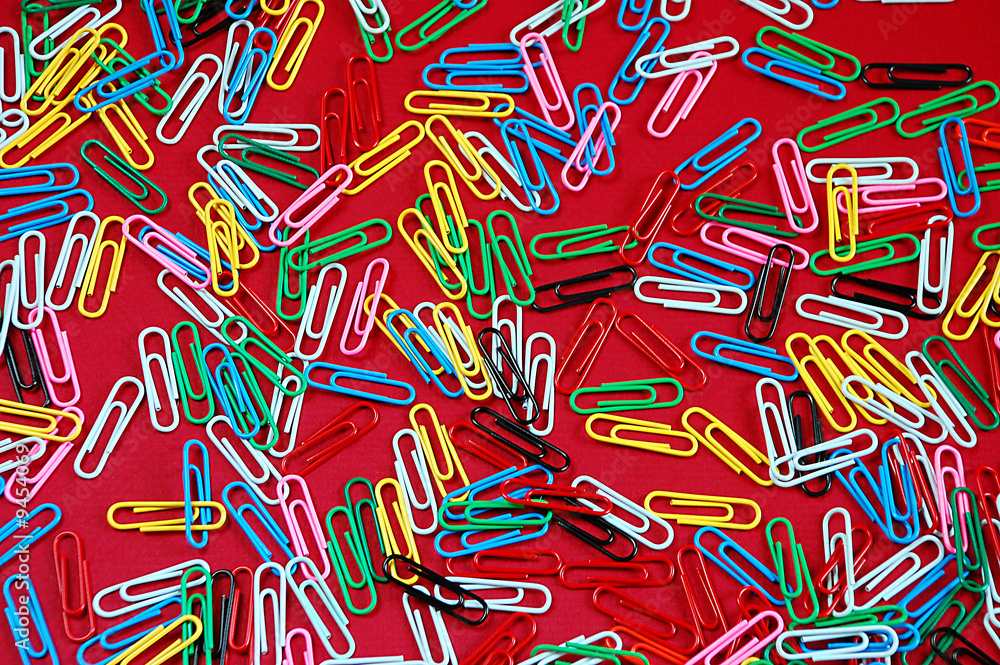 Colorful paperclips on red background Colorful paperclips on red background