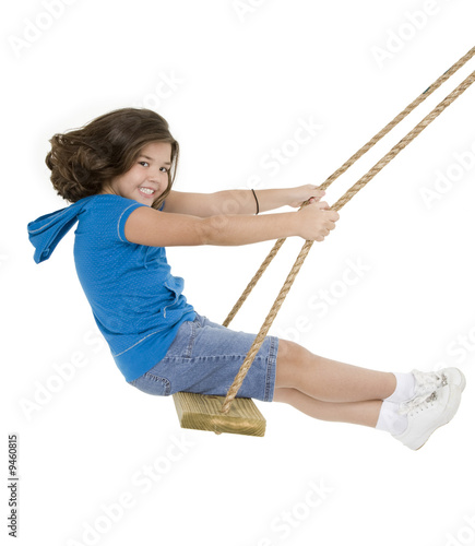 Caucasian child playing on a swing on white background